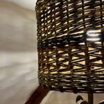 Light shining through a brown willow lampshade, showing off the zig-zag weave and French rand detail.