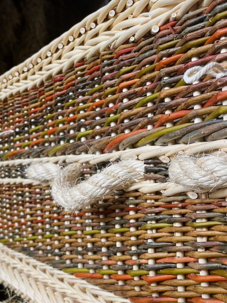 Zoomed in side view of colourful willow coffin showing sisal rope details