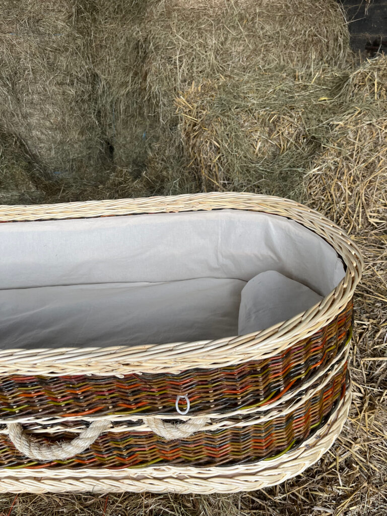 Inside view of a coffin showing lining, mattress and pillow