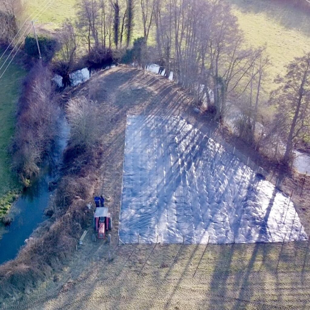 View over the willow bed from a drone, showing how it is placed in a bend of the river