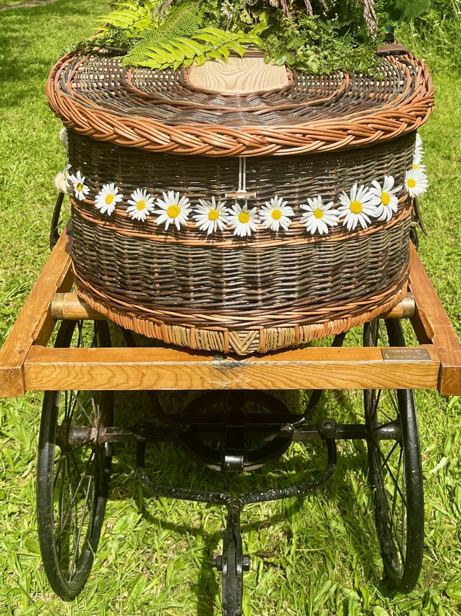 Front view of a woven base coffin on a bier