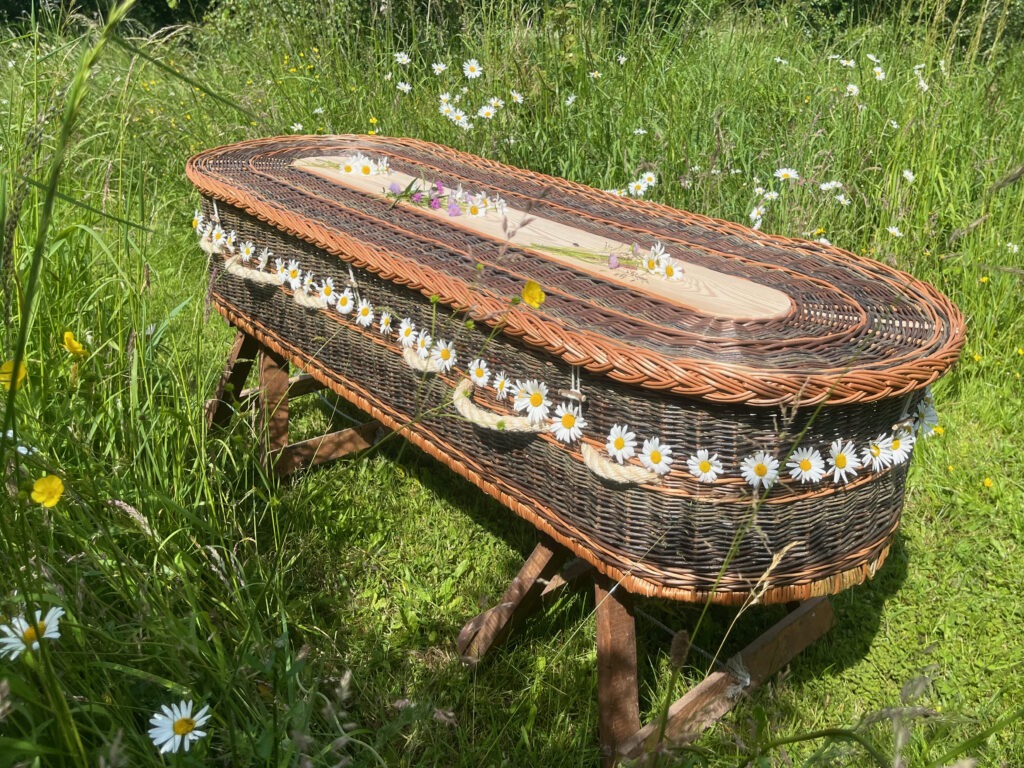 Woven base coffin on trestles in the grass at Humber Woodland of Remembrance