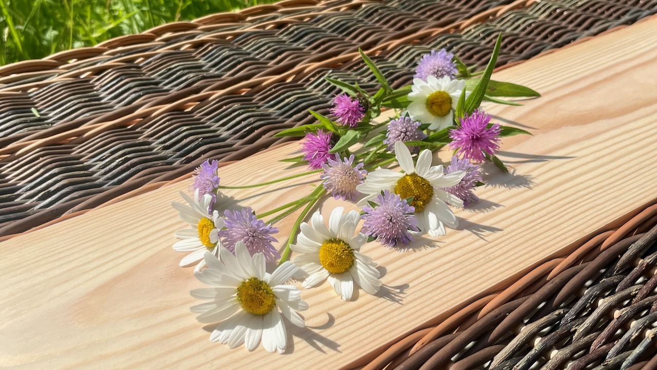 Wildflowers placed on Willow Coffin Lid with wooden centre