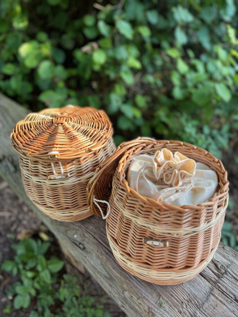 Two ashes caskets on a bench, one with the lid off showing the calico bag inside. 