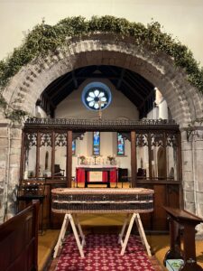 Willow Coffin stood on trestles in a Church looking towards the altar