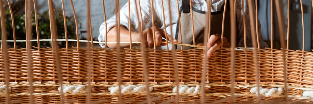 Close up of Steph's hands weaving part of the willow coffin